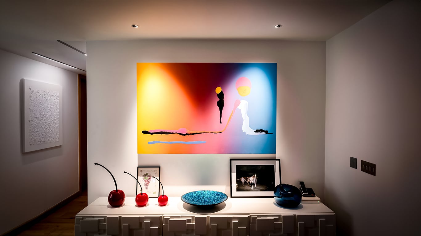 Artwork lit by two adjustable downlights recessed into ceiling